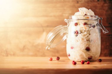 Ahşap arka planda cam kavanozda lahana turşusu ve fotokopi alanı. Evde mayalanmış ve marine edilmiş lahana. En iyi probiyotik gıdalar.