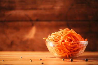 Ahşap arka planda baharatlı Kore havuç salatası. Uzayı kopyala Koryo-saram mutfağı.