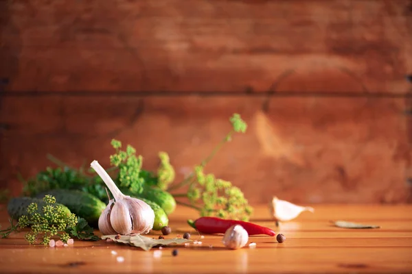 Ingredienti, spezie ed erbe per l'inscatolamento di cetrioli su fondo di legno. Ricevuto. Fiori di aneto, foglia di alloro, foglia di rafano, aglio, cetriolini . — Foto Stock