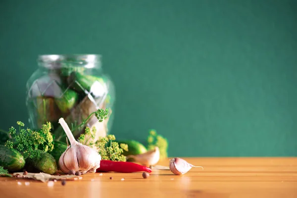 Ingredienti, spezie ed erbe per l'inscatolamento di cetrioli su fondo verde. Ricevuto. Fiori di aneto, foglia di alloro, foglia di rafano, aglio, cetriolini . — Foto Stock