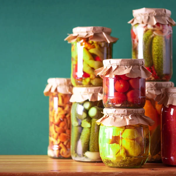 Verduras conservadas en frascos de vidrio sobre fondo verde. Copiar espacio. Concepto de comida fermentada saludable. Concepto de cosecha — Foto de Stock