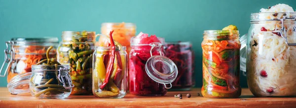 Antecedentes alimentarios probióticos. Zanahoria coreana, kimchi, remolacha, chucrut, pepinos en escabeche en frascos de vidrio. Concepto de alimentos fermentados y enlatados de invierno. Banner con espacio de copia — Foto de Stock