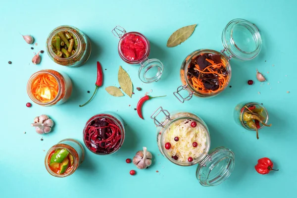 Probiotics food background. Korean carrot, kimchi, beetroot, sauerkraut, pickled cucumbers in glass jars. Top view. Winter fermented and canning food concept. Banner with copy space