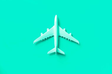 Beyaz uçak, trend yeşili ve turkuaz renkli uçak. Kopya alanı olan gökkuşağı gradyan arkaplan. Üst manzara, düz yatış. Asgari tarz tasarım. Seyahat, tatil konsepti.