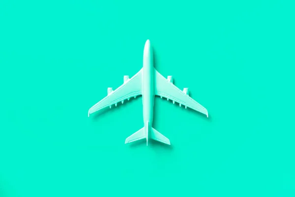 White plane, airplane in trendy green and turquoise color. Rainbow gradient background with copy space. Top view, flat lay. Minimal style design. Travel, vacation concept. — Stock Photo, Image