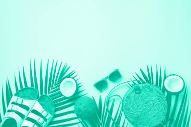 Şık bir rattan çanta, hindistan cevizi, hindistancevizi, palmiye dalları, nane rengi arka planda güneş gözlüğü. Moda yeşili ve turkuaz rengi. Moda bambu çanta ve ayakkabılar. Yaz moda yatağı