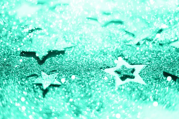 Fête de Noël. Contexte abstrait pour la fête du nouvel an. Patter of gold stars with lights, bokeh. Couleur verte et turquoise tendance. Étoiles scintillantes de couleur menthe — Photo