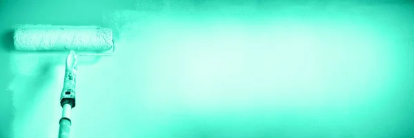 Ручная роспись стены с краски ролика в мятном цвете. Ремонт, ремонт, строительство и концепция дома. Традиционный зеленый и бирюзовый цвет. Принято, баннер. Инструменты для покраски стен . — стоковое фото