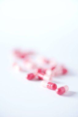 Pembe kapsüller, haplar, beyaz arka planda vitaminler. Uzayı kopyala Bir sürü ilaç, soğuk algınlığı tedavisi. Kadın hastalıkları tedavisi. Pankart