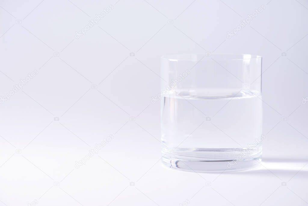 Glass of water over grey background. Copy space. Water balance