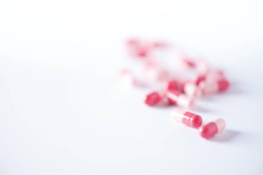 Pembe kapsüller, haplar, beyaz arka planda vitaminler. Uzayı kopyala Bir sürü ilaç, soğuk algınlığı tedavisi. Kadın hastalıkları tedavisi. Pankart