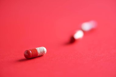 Kırmızı arka planda kırmızı kapsüller. Uzayı kopyala Bir sürü ilaç, soğuk algınlığı tedavisi. Coronavirus Covid-19.