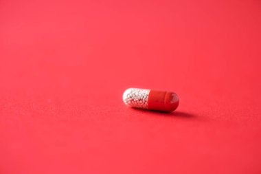 Kırmızı arka planda kırmızı kapsüller. Uzayı kopyala Bir sürü ilaç, soğuk algınlığı tedavisi. Coronavirus Covid-19.