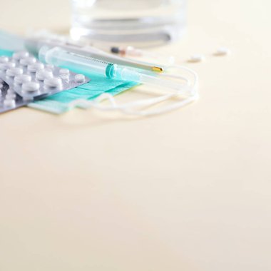 Bir sürü ilaç, soğuk algınlığı tedavisi. Virüs saldırısı. Grip tedavisi için ayarlandı. Haplar, kapsüller, termometre, koruyucu cerrahi maske, şırınga. Uzayı kopyala Pankart. Coronavirus Covid-19