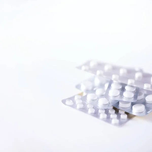 Πολλά λευκά καψάκια σε συσκευασία κυψέλης σε λευκό φόντο. Αντιγραφή χώρου. Φάρμακα, θεραπεία κρυολογήματος. Ιός του Coronavirus Covid-19. — Φωτογραφία Αρχείου