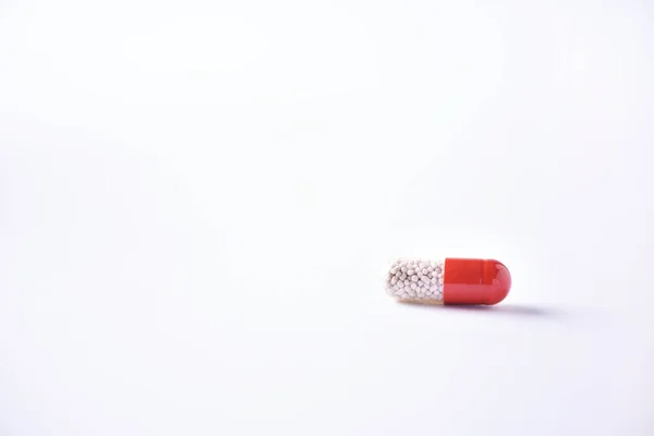 Macro of red capsules on white background. Copy space. Bunch of drugs, cold flu treatment. Coronavirus Covid-19. — Stock Photo, Image