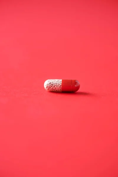 Μακρο από κόκκινες κάψουλες σε κόκκινο φόντο. Αντιγραφή χώρου. Φάρμακα, θεραπεία κρυολογήματος. Ιός του Coronavirus Covid-19. — Φωτογραφία Αρχείου