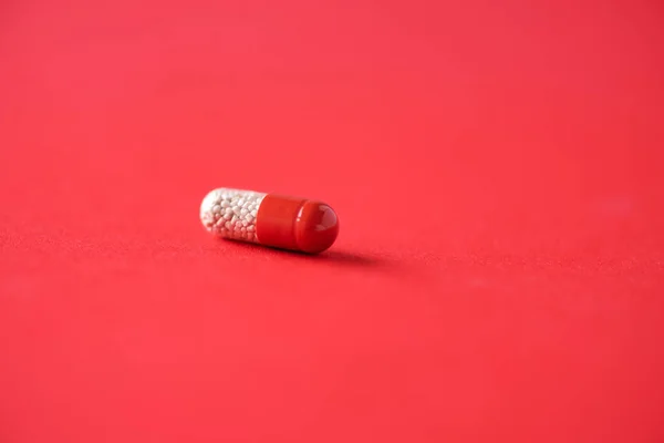 Macro of red capsules on red background. Copy space. Bunch of drugs, cold flu treatment. Coronavirus Covid-19. — Stock Photo, Image