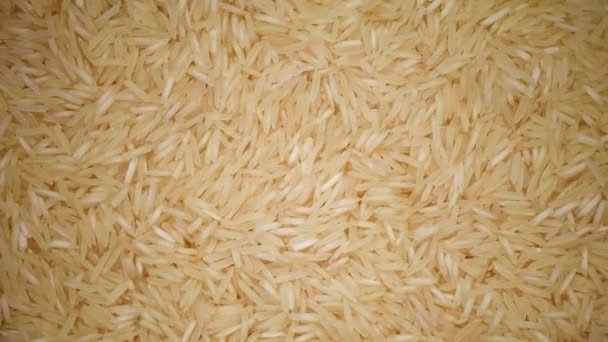 Fehér nyers bio basmati rizs forgatási háttér. Élelmiszer-összetevő háttér. Top view, egészséges életmód koncepció. — Stock videók