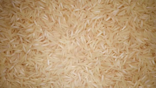 Beyaz çiğ organik basmati pirinç dönüş arkaplanı. Yemek malzemesi geçmişi. Üst görünüm, sağlıklı yaşam tarzı konsepti. — Stok video