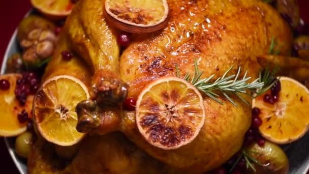 Kerstdiner met het gezin. Geroosterde kip met kruiden, sinaasappelen, veenbessen op roterende achtergrond, slow-motion schieten. — Stockvideo
