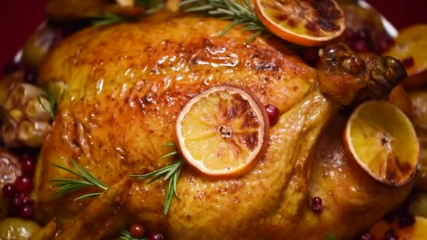 Cena di Natale in famiglia. Pollo arrosto con erbe, arance, mirtilli rossi su sfondo rotante, riprese al rallentatore . — Video Stock