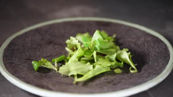 Vegan e conceito de alimentos crus. Misturando salada verde caindo em prato de pedra. Vista superior . — Vídeo de Stock