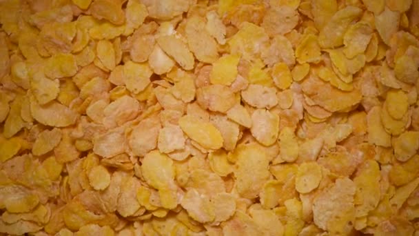 Goldene Cornflakes zum Frühstück auf rotierendem Hintergrund. Hintergrund der Lebensmittelzutaten. Draufsicht, gesundes Lebensstil-Konzept. Vegane gesunde Ernährung — Stockvideo