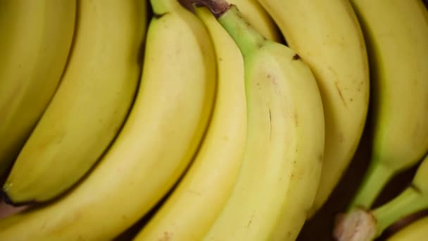 Bananes sur fond rotatif. Vue de dessus. Concept alimentaire végétalien et cru. Bouquet de bananes jaunes — Video