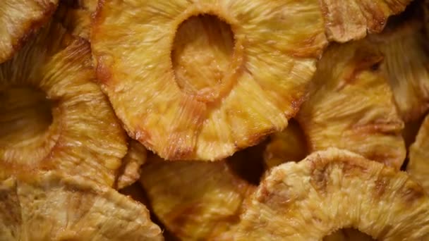 Φέτες αποξηραμένου ανανά σε περιστρεφόμενο φόντο. Στο πάνω μέρος. Χορτοφαγική δίαιτα. Υγιεινός τρόπος ζωής Ξερά φρούτα φόντο. Γλυκοί ανανάδες, βιολογικά τρόφιμα. — Αρχείο Βίντεο