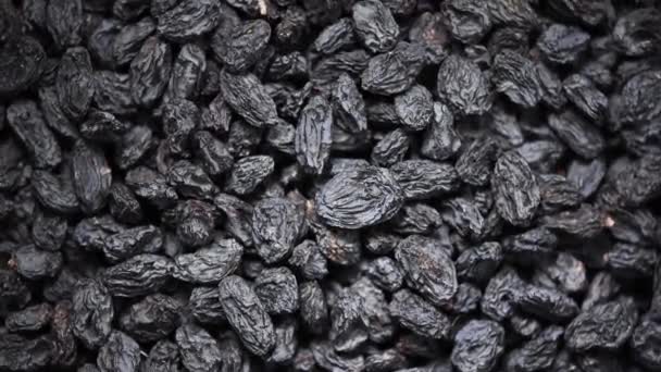 Black raisins on rotating background. Top view. Dried fruits background. Food ingredient background. Vegan, vegetarian diet. Healthy lifestyle. Fresh sweet raisin, organic food. — Stock Video