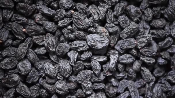 Black raisins on rotating background. Top view. Dried fruits background. Food ingredient background. Vegan, vegetarian diet. Healthy lifestyle. Fresh sweet raisin, organic food. — Stock Video