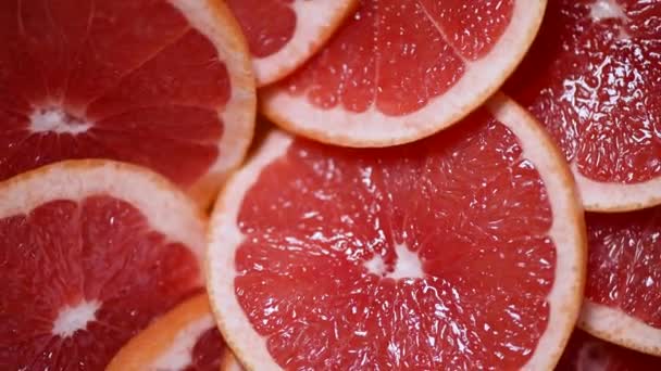 Grapefruit gesneden helft op roterende achtergrond. Citrusvruchten. Veganistisch en rauw voedsel concept. Rode grapefruits textuur. Bovenaanzicht — Stockvideo