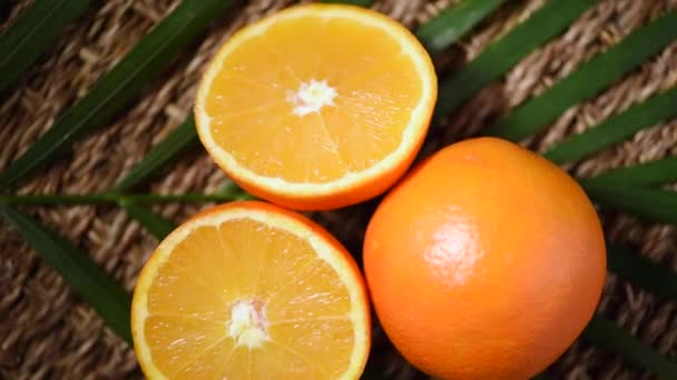 Egészséges narancssárga gyümölcsök a pálmaágon, forgó háttér. Első látásra. Citrusfélék. Vega és nyers étel koncepció. Lédús narancs háttér — Stock videók