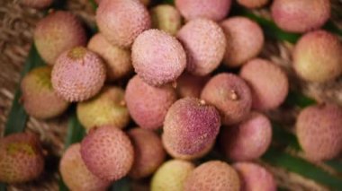 Dönen arka planda taze liçi meyveleri. Üst Manzara. Egzotik meyveler, tropik palmiye dalları. Vegan ve çiğ gıda konsepti.