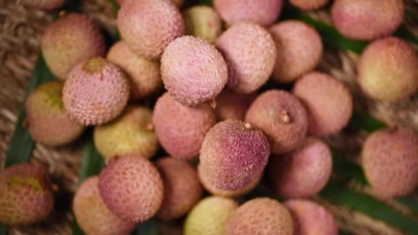 신선 한 라이 치 열매들 이 회전하는 배경에 있습니다. 위에서 본 모습. 이국적 인 과일, 열 대 야자나무가지. 채소 와식용 식품의 개념. — 비디오