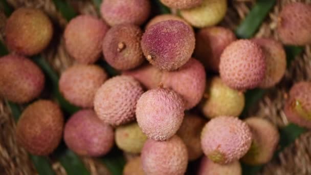 Frische Litschi-Früchte auf rotierendem Hintergrund. Ansicht von oben. Exotische Früchte, tropischer Palmenzweig. Veganes und Rohkost-Konzept. — Stockvideo