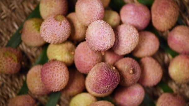 Vers lychee fruit op roterende achtergrond. Bovenaanzicht. Exotische vruchten, tropische palmtak. Veganistisch en rauw voedselconcept. — Stockvideo