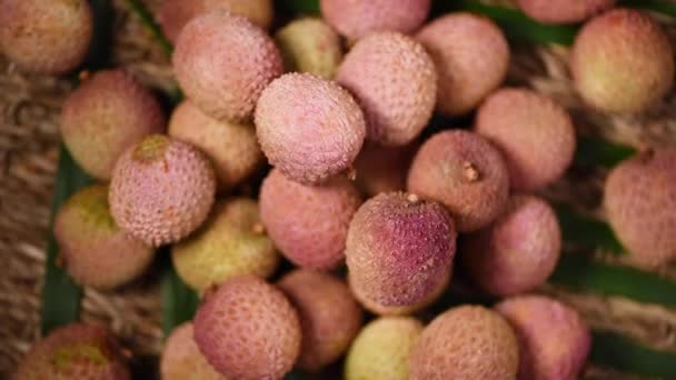 신선 한 라이 치 열매들 이 회전하는 배경에 있습니다. 위에서 본 모습. 이국적 인 과일, 열 대 야자나무가지. 채소 와식용 식품의 개념. — 비디오