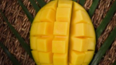 Arka planda dilimlenmiş mango. Üst Manzara. Egzotik meyve, tropik palmiye dalı. Vegan ve çiğ gıda konsepti