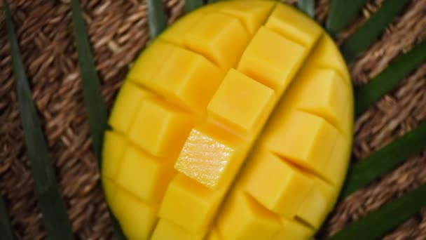 Mango affettato su sfondo rotante. Vista dall'alto. Frutto esotico, ramo di palma tropicale. Concetto di cibo vegano e crudo — Video Stock