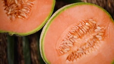 Arka planda turuncu kavun. Üst Manzara. Egzotik meyve, tropik palmiye dalı. Vegan ve çiğ gıda konsepti. Kavun, kavun, bitki.