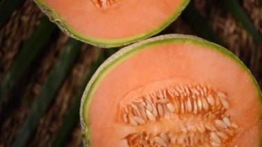 Arka planda turuncu kavun. Üst Manzara. Egzotik meyve, tropik palmiye dalı. Vegan ve çiğ gıda konsepti. Kavun, kavun, bitki.