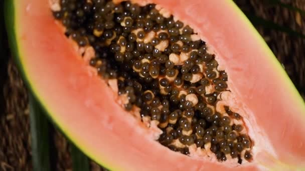 Ripe papaya on rotating background. Top view. Exotic fruit, tropical palm branch. Vegan and raw food concept. Cutted papaya in half — Stock Video