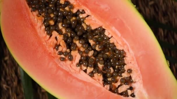 Ripe papaya on rotating background. Top view. Exotic fruit, tropical palm branch. Vegan and raw food concept. Cutted papaya in half — Stock Video