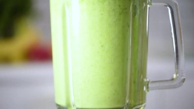 Meyveler, böğürtlenler ve sebzeler sağlıklı yeşil smoothie ile harmanlanmış. Detoks ve sağlıklı yaşam tarzı konsepti. Vejetaryen diyeti. Kahvaltı hazırlığı.