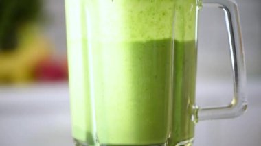 Detoks ve sağlıklı yaşam tarzı konsepti. Meyveler, böğürtlenler ve sebzeler sağlıklı yeşil smoothie ile harmanlanmış. Vejetaryen diyeti. Kahvaltı hazırlığı.