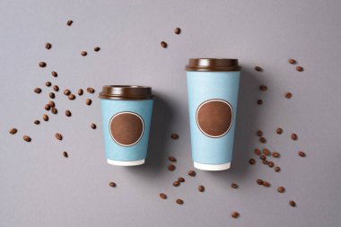 Gri arka planda kahve fincanı ve kahve çekirdeklerini çıkar. Üst Manzara. Uzayı kopyala Minimum bileşim, tasarım için tasarım. Kahve konsepti.