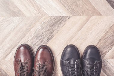 Ahşap arka planda siyah ve kahverengi ayakkabı renkleri. Satış ve alışveriş konsepti. Uzayı kopyala Pankart. Klasik kış sıcacık erkek ayakkabıları.