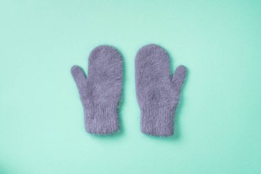 Noel ve Yeni Yıl kompozisyonu. Mavi arka planda örülmüş eldivenler. Düz yatış, üst görünüm